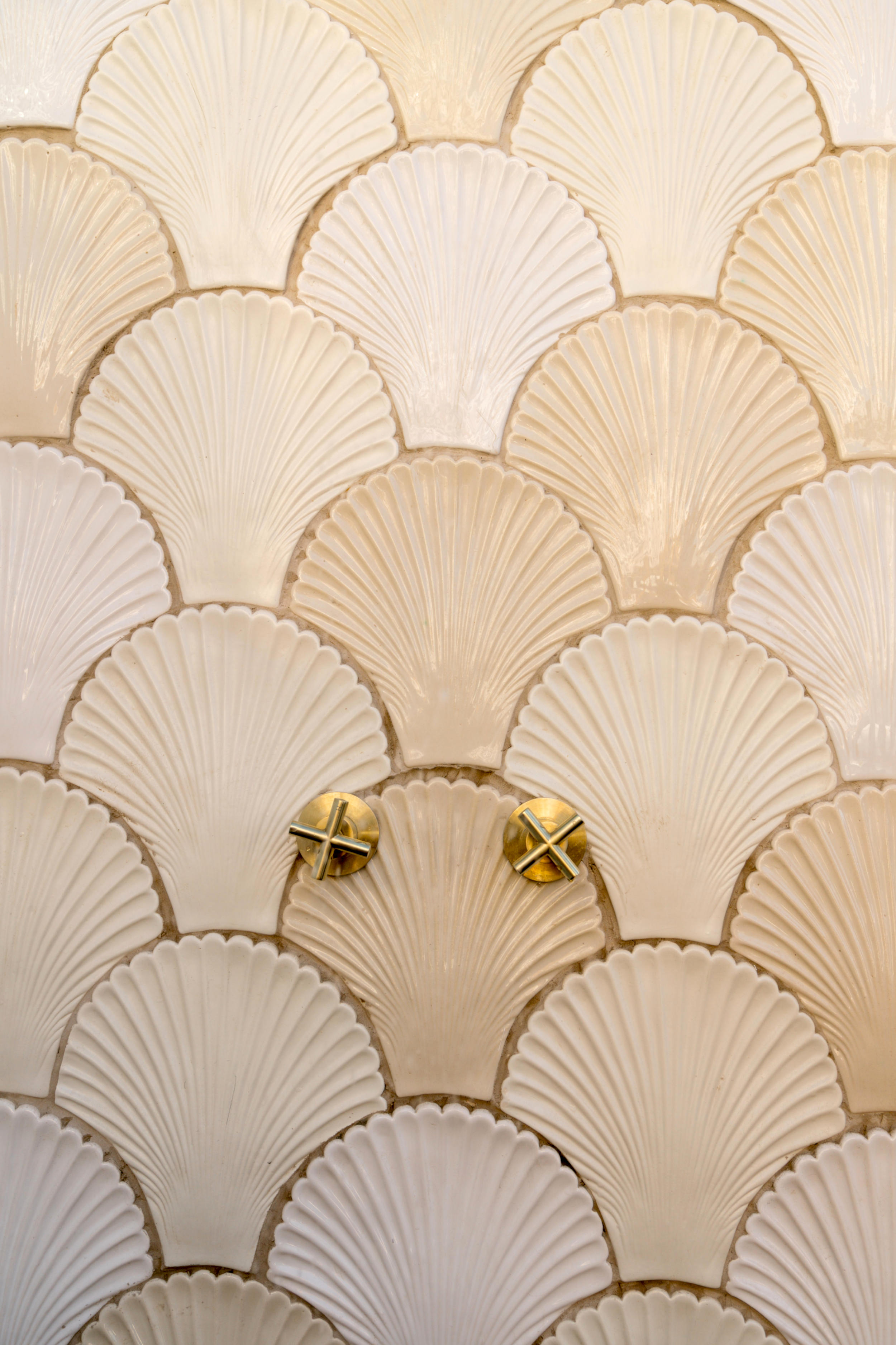 Handmade Gifts of the Sea wall tiles in soft cement pink and white with a shell-inspired design