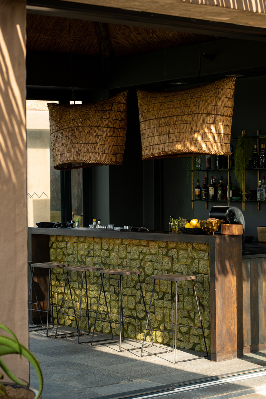 Handcrafted Separate Reality ceramic tile installation in olive green featuring intricate geometric relief patterns applied to a bespoke bar frontage.