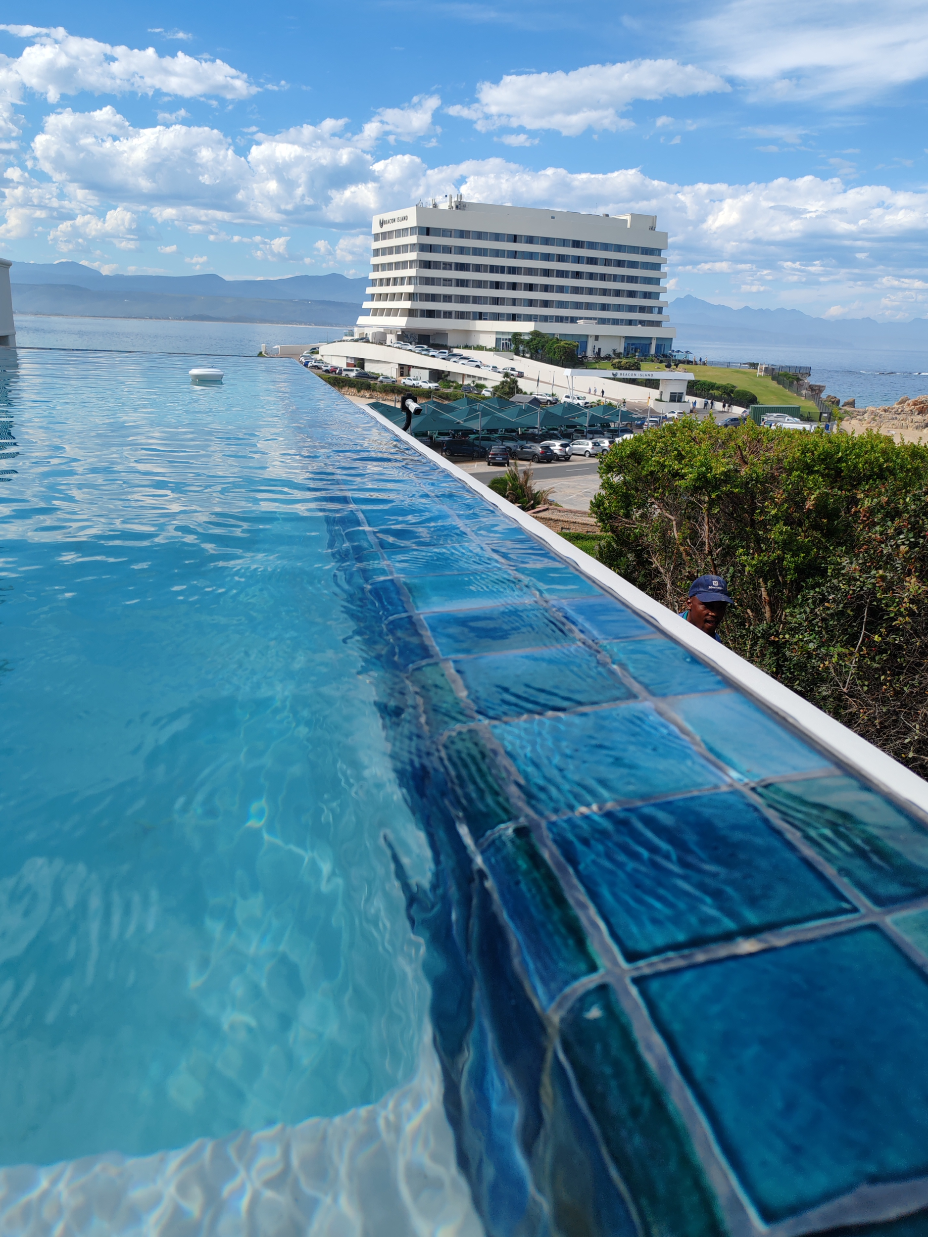 Luxury infinity pool finished with Amazon Blue ceramic tiles overlooking the coastline and mountains. Description