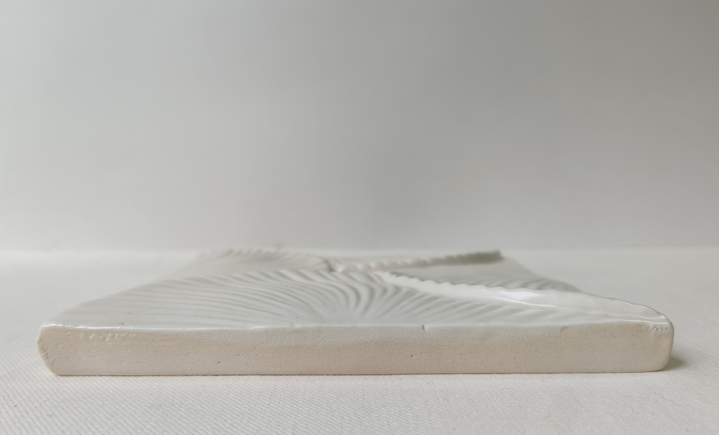 Handcrafted Thousand Petal Lotus ceramic tile in white, showcasing an intricate flowing relief pattern and artisan-crafted profile.