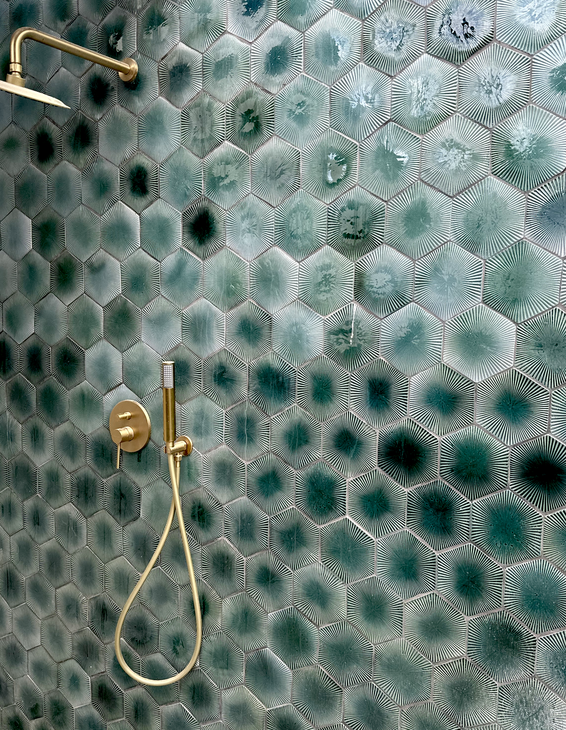 Handcrafted City of Jewels hexagon tiles in Forest Green installed as a textured bathroom feature wall with brass tapware.