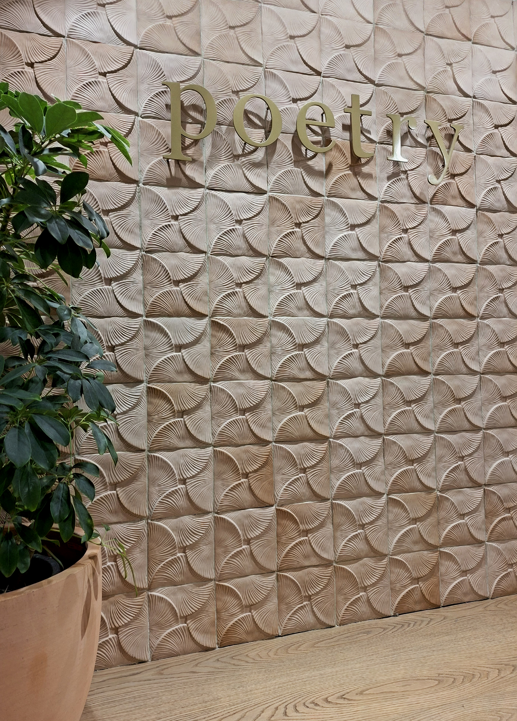 Feature wall installation using Thousand Petal Lotus handcrafted ceramic tiles in light terracotta, creating a textured decorative backdrop with a natural organic pattern.