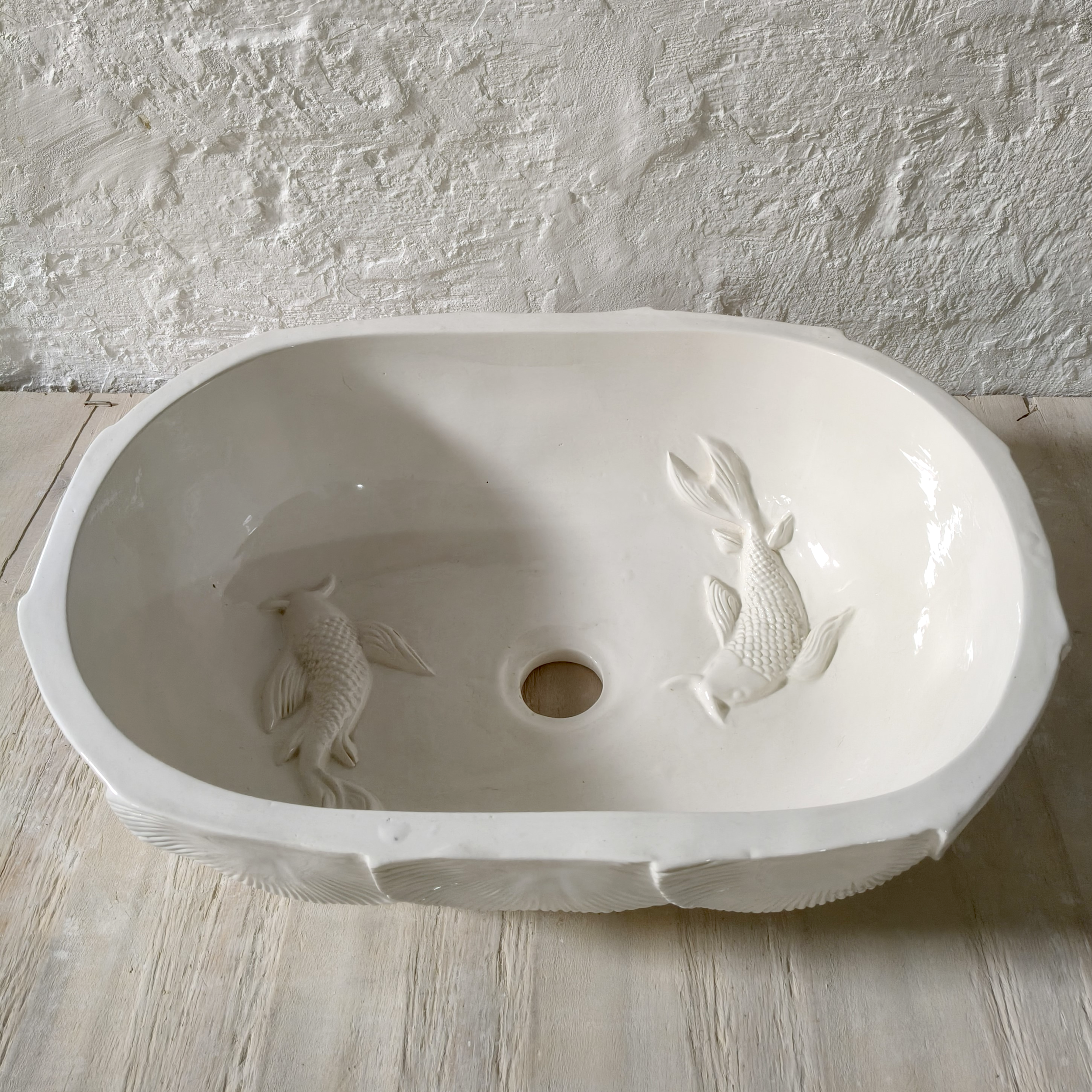 Large handcrafted white ceramic basin with textured shell-inspired relief pattern and contemporary organic design.